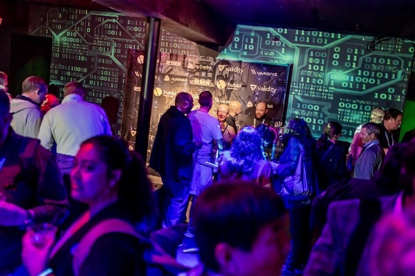 a group of people in a room with a wall with a green and blue light